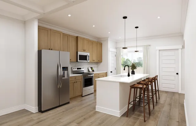 a kitchen with stainless steel appliances a refrigerator a stove a sink and white cabinets with wooden floor