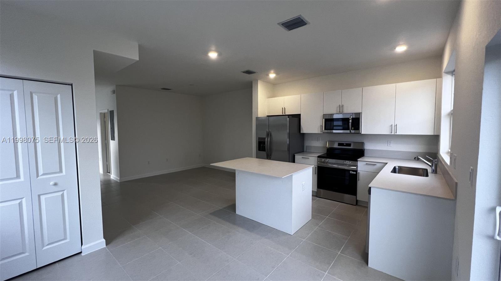 15583 Southwest 277th Street, Unit 15583 Homestead, FL 33032 - Photo 4 of 27 a kitchen with cabinets and stainless steel appliances