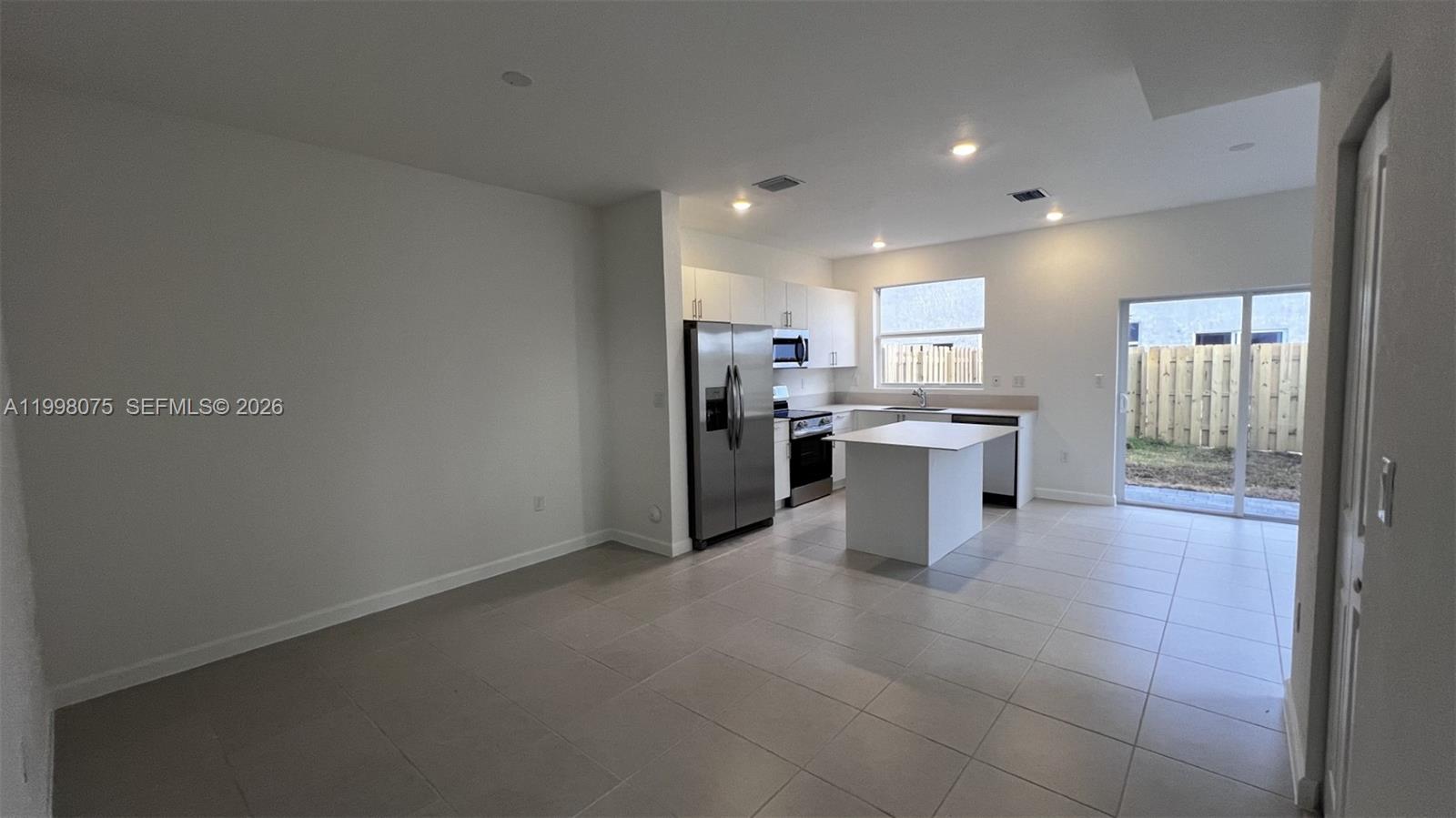 15583 Southwest 277th Street, Unit 15583 Homestead, FL 33032 - Photo 8 of 27 a kitchen with stainless steel appliances granite countertop a refrigerator and a sink