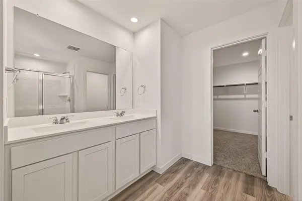 a bathroom with a double vanity sink a mirror and a shower