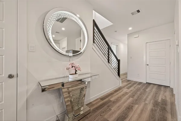 a very nice looking room with wooden floor and white walls