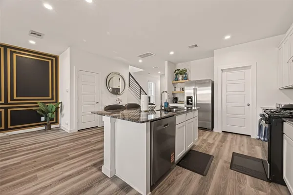 a kitchen with stainless steel appliances granite countertop a stove and a refrigerator