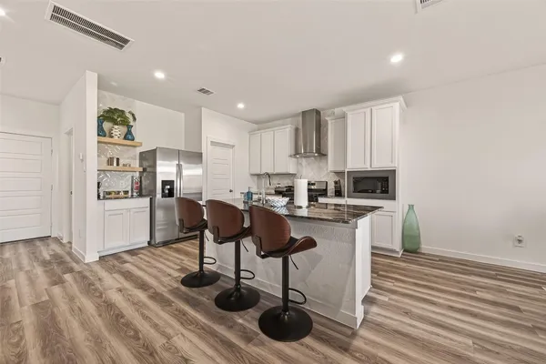 a kitchen with a sink cabinets and wooden floor