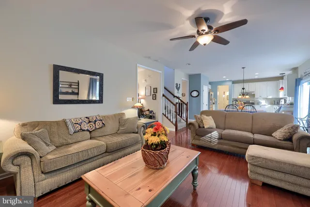 a living room with furniture kitchen view and a chandelier