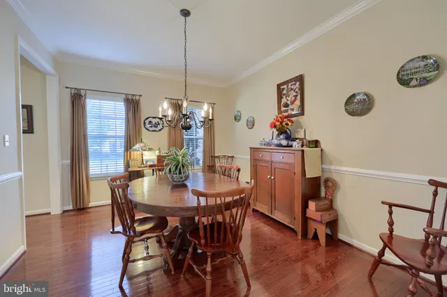 a view of a dining room and livingroom with furniture wooden floor a chandelier
