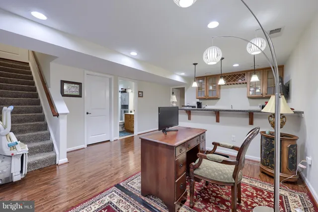 a kitchen with stainless steel appliances kitchen island granite countertop a table chairs and a refrigerator