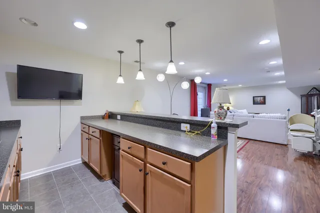 a kitchen with stainless steel appliances granite countertop a sink a stove and a wooden floors