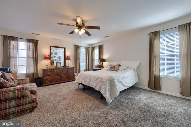 a spacious bedroom with a bed couch and window