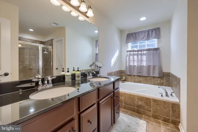 a bathroom with a bathtub double vanity sink and a mirror