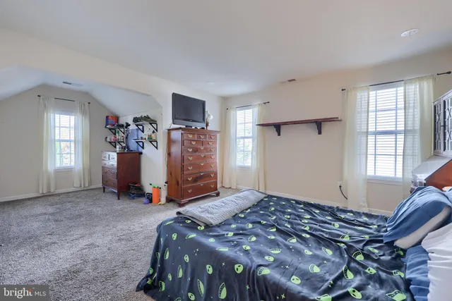 a bed sitting in a room next to a window and a lamp