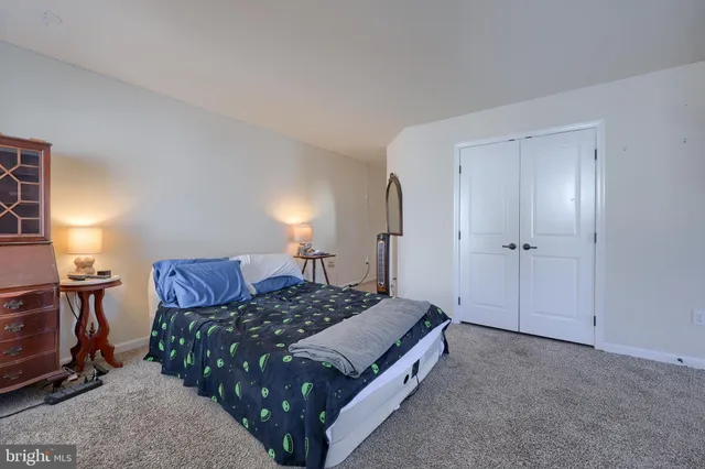 a spacious bedroom with a bed and chair