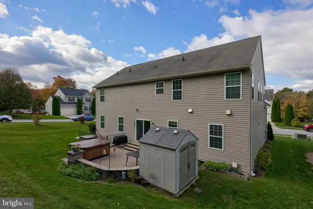 a backyard of a house with table and chairs plants and outdoor kitchen