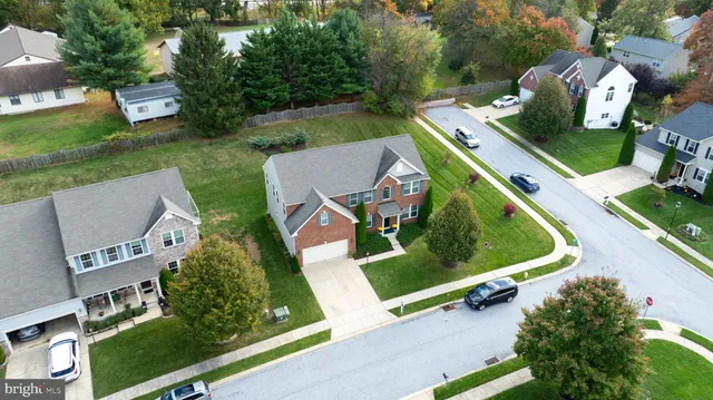 an aerial view of a residential houses with yard