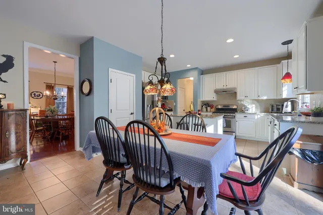 a dining room filled chandelier and wooden floor