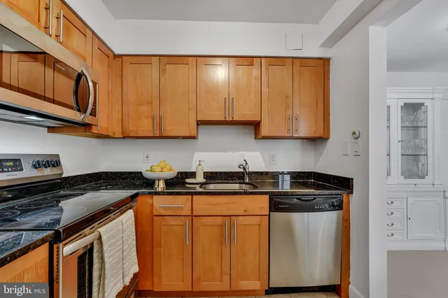 a kitchen with stainless steel appliances granite countertop a stove a sink and dishwasher with cabinets