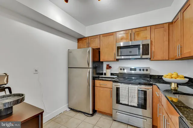 a kitchen with stainless steel appliances granite countertop a refrigerator stove top oven a sink and dishwasher