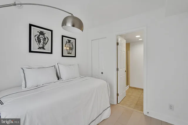 a bedroom with a large bed and painting on the wall