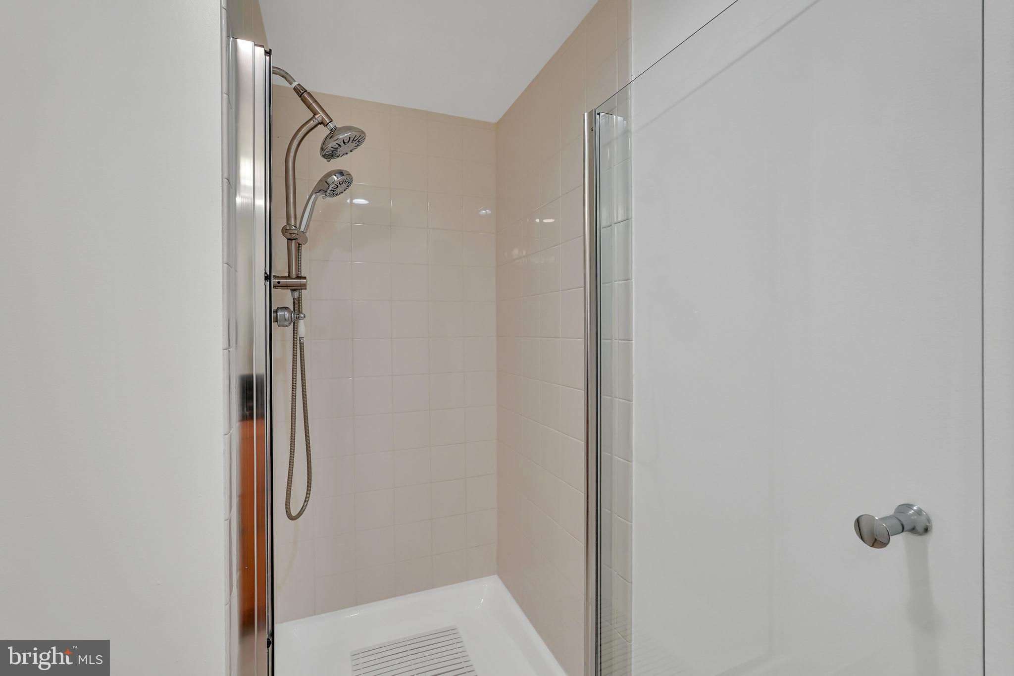 3401 38th Street Northwest, Unit 407 Washington, DC 20016 - Photo 19 of 37 a bathroom with a glass shower door