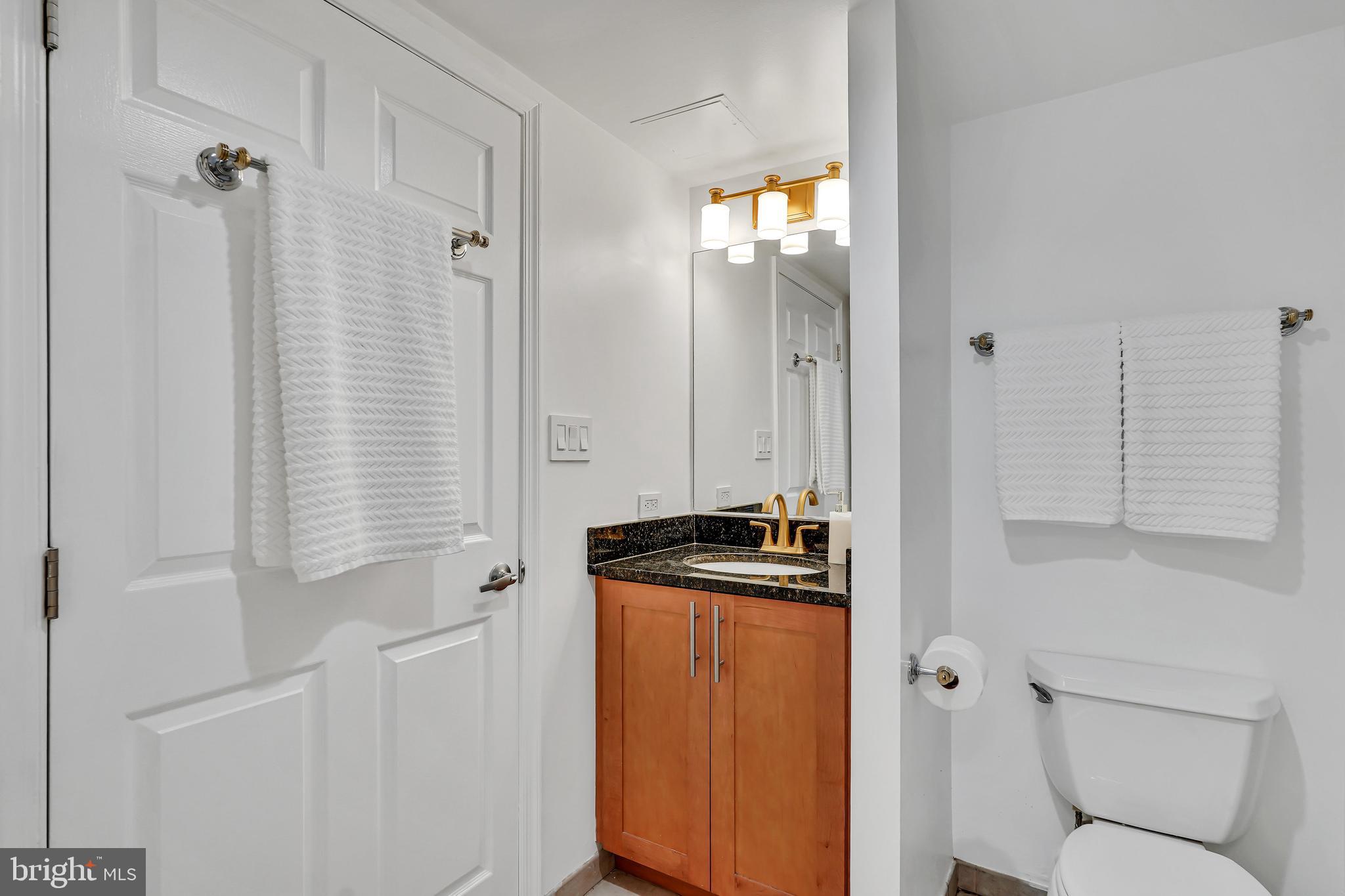 3401 38th Street Northwest, Unit 407 Washington, DC 20016 - Photo 25 of 37 a bathroom with a granite countertop sink toilet and shower