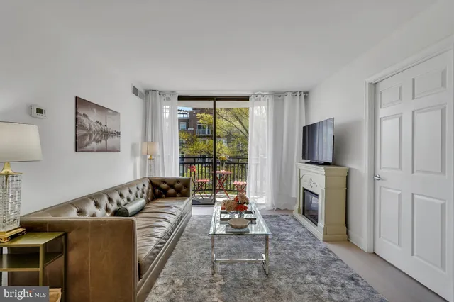 a living room with furniture a large window and a flat screen tv