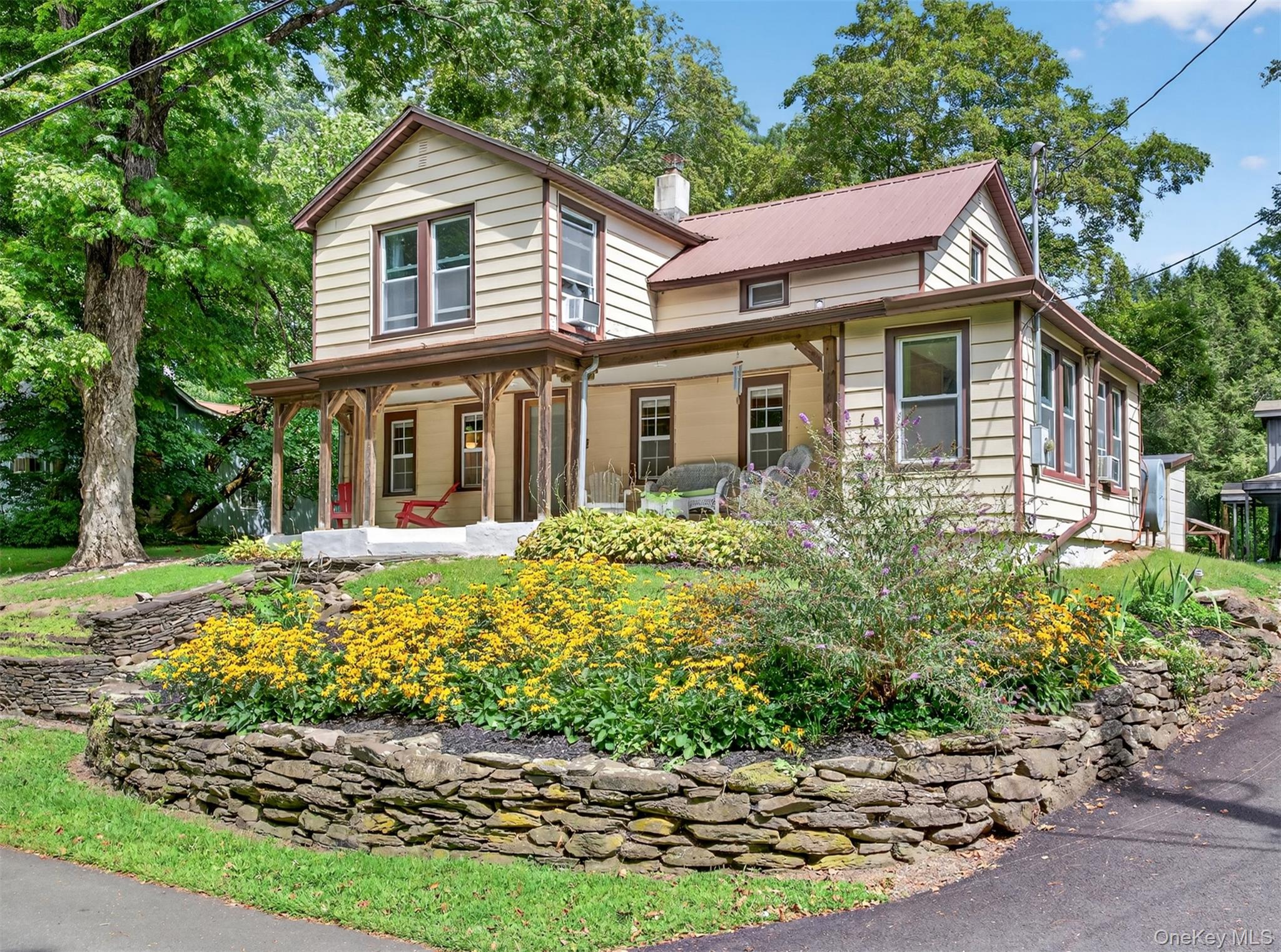View of front facade featuring covered porch and a chimney