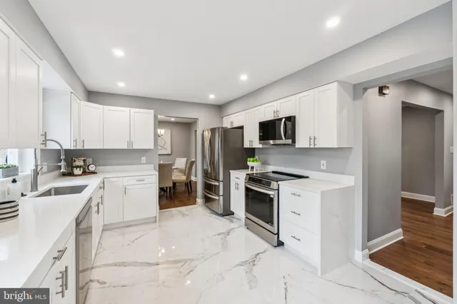 a kitchen with a sink a stove top oven and cabinets