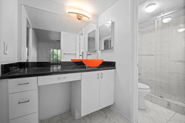 a white toilet sitting next to a bathroom sink