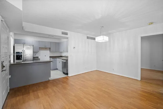 a view of empty room with wooden floor and window