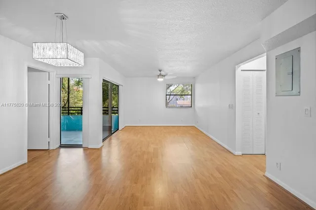 a kitchen with stainless steel appliances granite countertop a sink dishwasher a stove and white cabinets with wooden floor