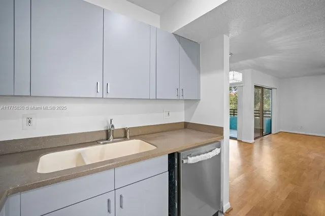 a view of a kitchen with wooden floor and natural light