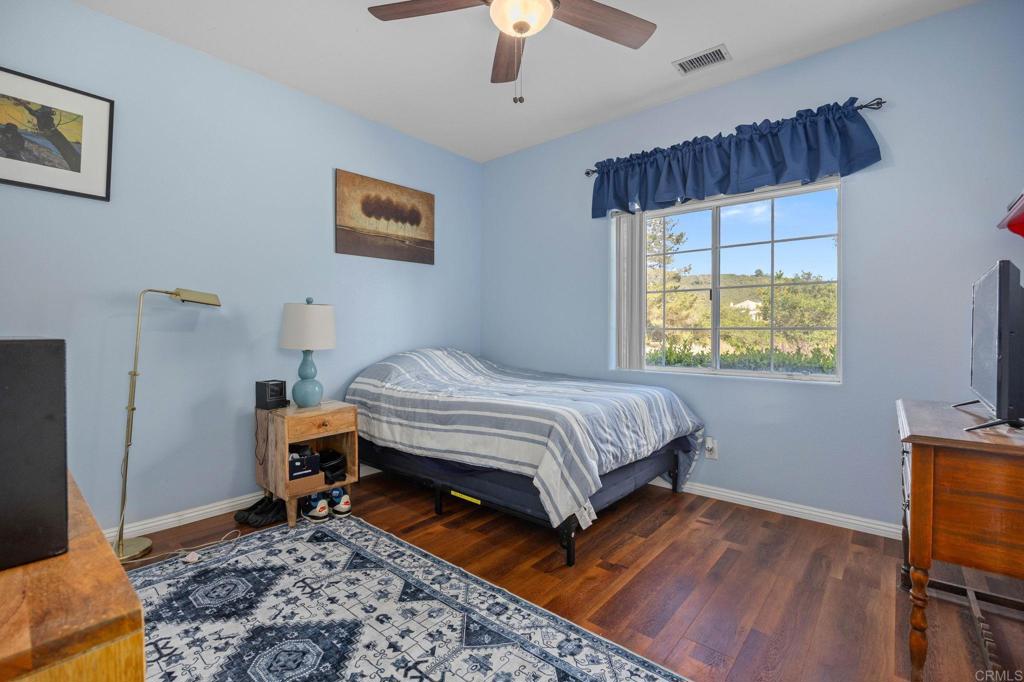 7635 Little Creek Road San Marcos, CA 92078 - Photo 23 of 48 a bedroom with a bed a chandelier and a window