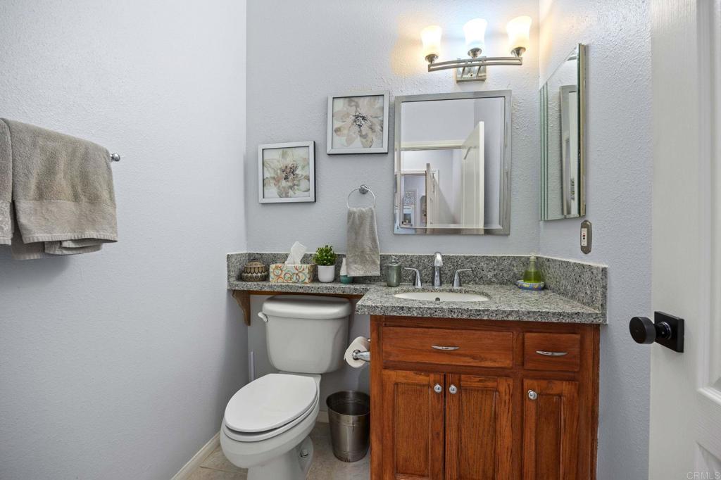 7635 Little Creek Road San Marcos, CA 92078 - Photo 24 of 48 a bathroom with a granite countertop toilet sink and mirror