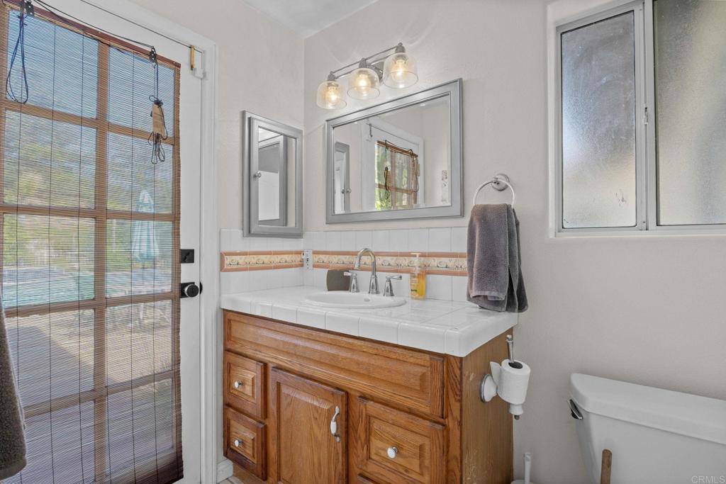 7635 Little Creek Road San Marcos, CA 92078 - Photo 32 of 48 a bathroom with a granite countertop sink and a mirror