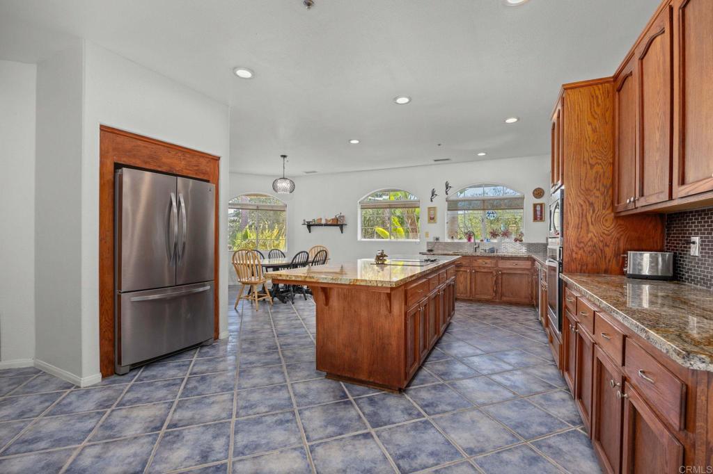 7635 Little Creek Road San Marcos, CA 92078 - Photo 9 of 48 a kitchen with stainless steel appliances granite countertop a refrigerator a sink a stove a microwave and island