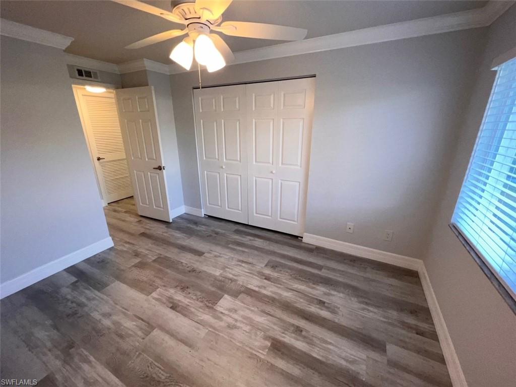 409 Gabriel Circle, Unit 2203 Naples, FL 34104 - Photo 13 of 18 wooden floor in an empty room with a window
