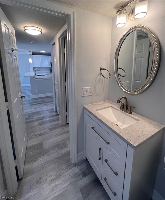 409 Gabriel Circle, Unit 2203 Naples, FL 34104 - Photo 15 of 18 a bathroom with a granite countertop sink toilet and a mirror