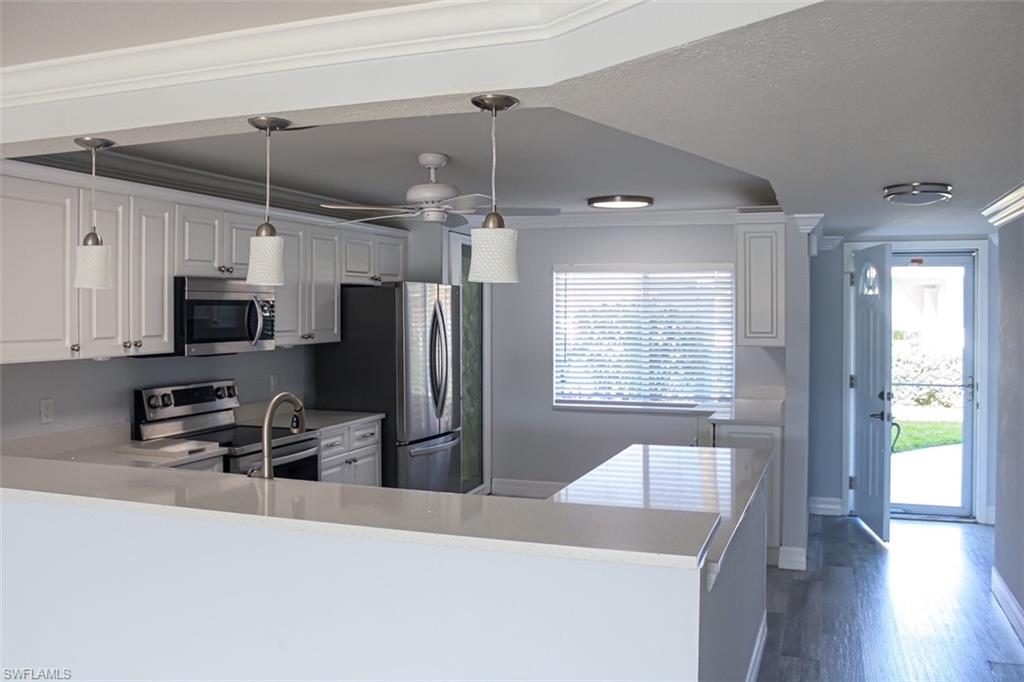409 Gabriel Circle, Unit 2203 Naples, FL 34104 - Photo 4 of 18 a kitchen with stainless steel appliances a stove a refrigerator and a sink