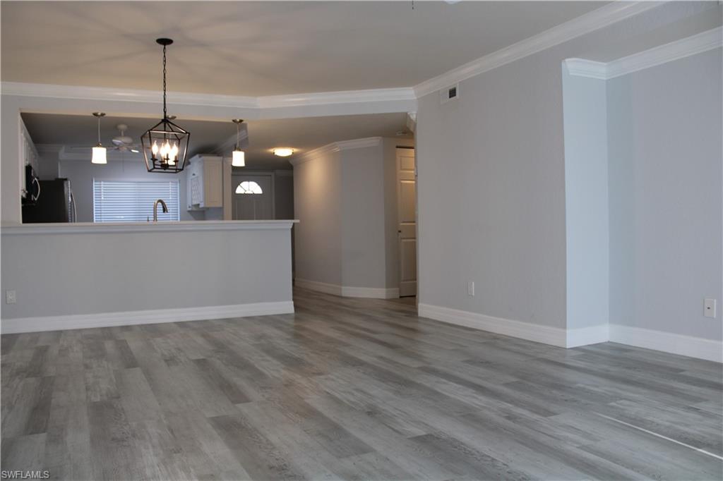 409 Gabriel Circle, Unit 2203 Naples, FL 34104 - Photo 8 of 18 a view of a room with wooden floor and kitchen view