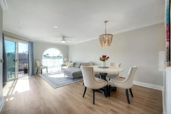 a dining room with furniture a chandelier and wooden floor