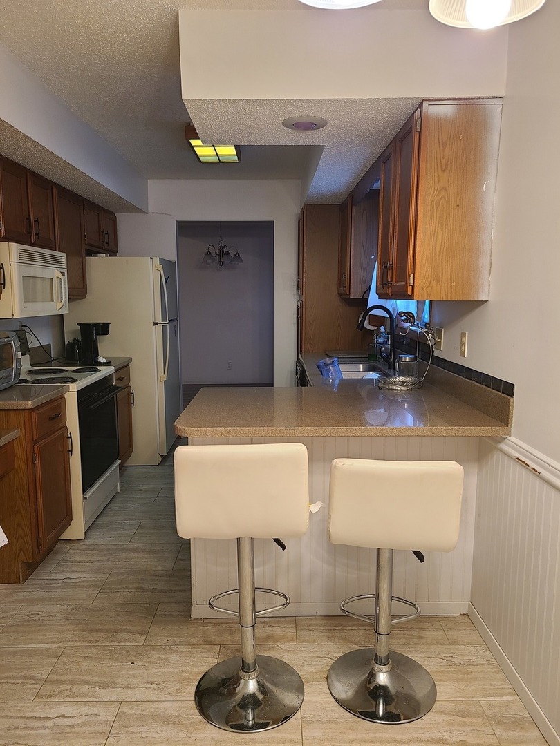 2001 Eagle Ridge Court, Unit A Urbana, IL 61802 - Photo 11 of 30 a kitchen with stainless steel appliances granite countertop a sink refrigerator and cabinets