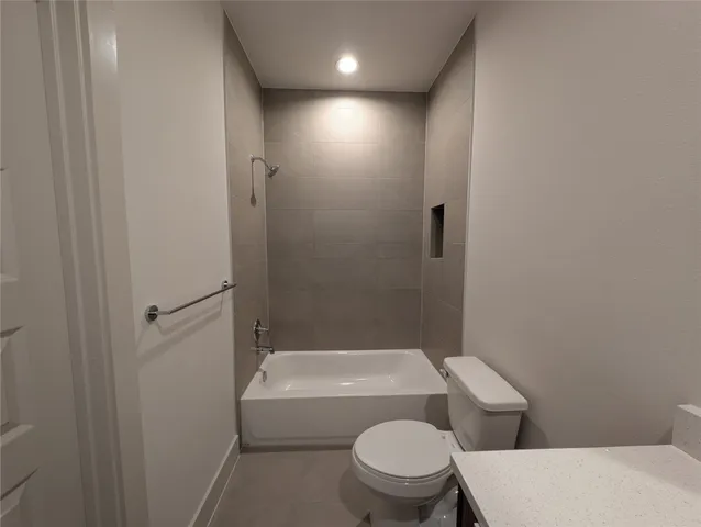 a white toilet sitting next to a bath tub