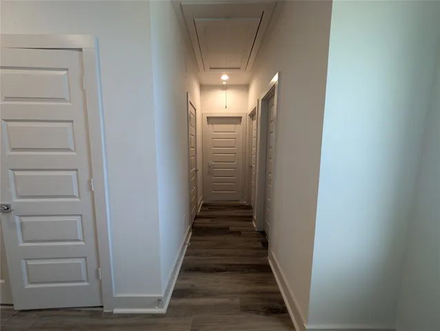 a view of a hallway with stairs and wooden floor