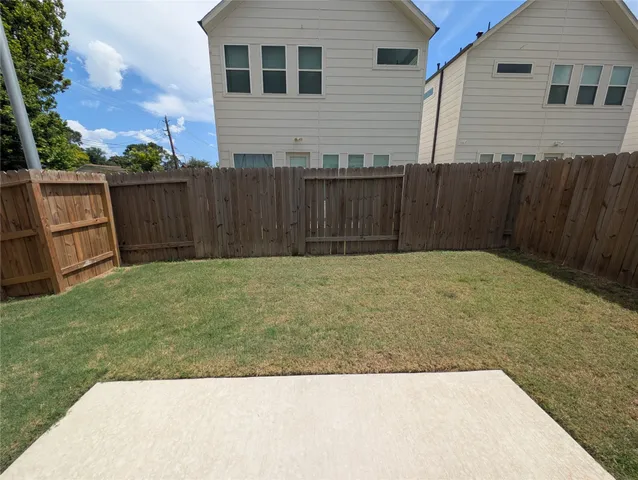 a view of backyard with wooden fence