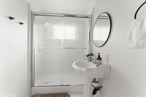 a bathroom with a sink a mirror a vanity and shower