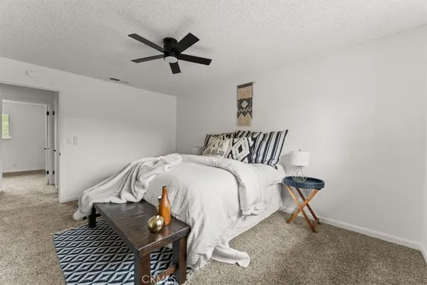 a bedroom with a bed and a ceiling fan