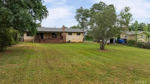 a view of a house with a yard and sitting area