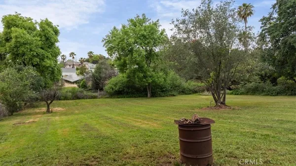 a backyard of a house with lots of green space and fountain