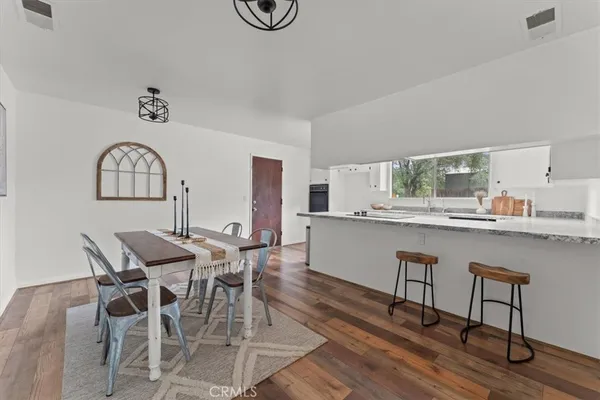 a view of a a dining room with furniture window and wooden floor