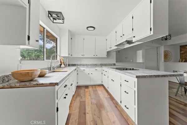 a kitchen with granite countertop a sink stove and cabinets