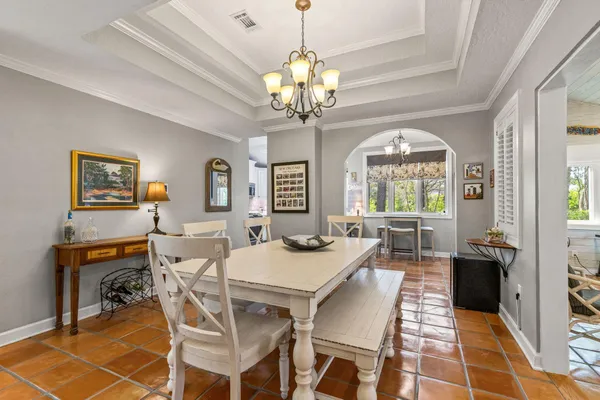 a view of a dining room with furniture and a chandelier